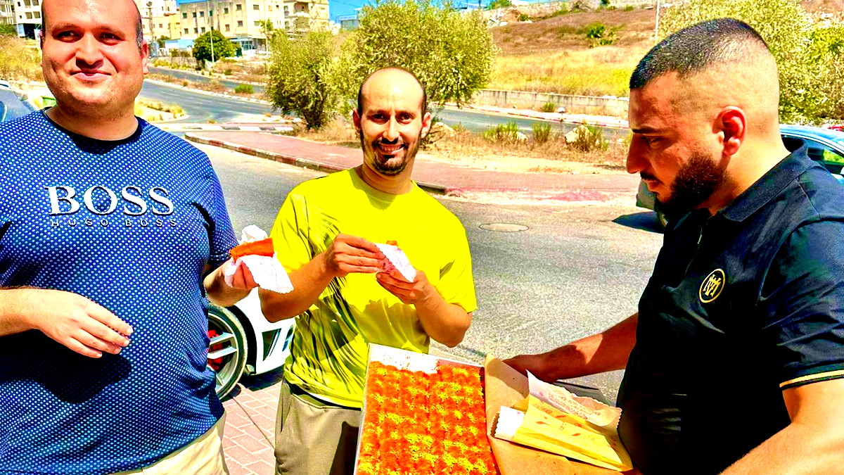 توزيع الحلويات والماء والقهوة على المارين  في حي الفاخورة في الناصرة احتفالاً بالمولد النبوي الشريف